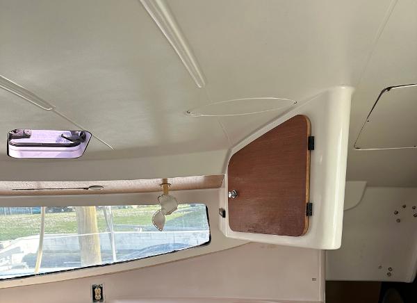 Slide: The Image of Interior of 1998 Fountaine Pajot Athena 38 catamaran, featuring a wooden cabinet and window. - 10