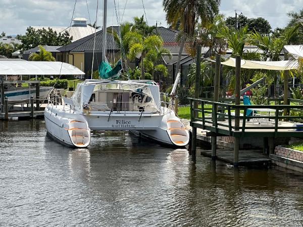 Slide: The Image of Fountaine Pajot Athena 38 catamaran docked in a scenic canal, surrounded by lush greenery. - 42