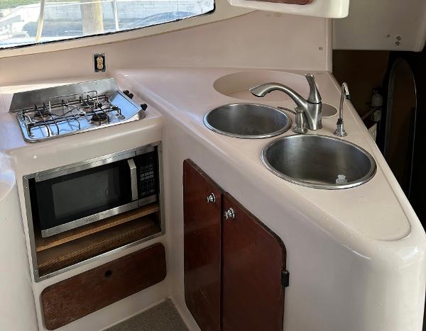 Slide: The Image of 1998 Fountaine Pajot Athena 38 yacht kitchen with stove, microwave, and dual sinks. - 8