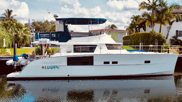 Slide: The Image of 2015 Fountaine Pajot Cumberland 47 LC yacht docked by palm trees. - 0