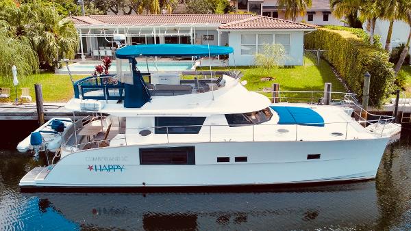 Slide: The Image of 2015 Fountaine Pajot Cumberland 47 LC yacht docked by a modern house. - 1