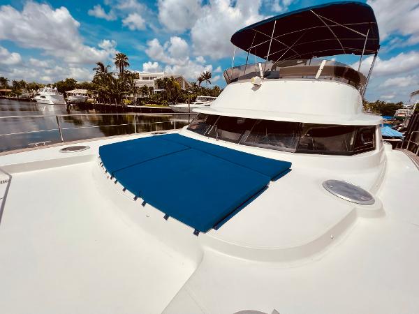 Slide: The Image of 2015 Fountaine Pajot Cumberland 47 LC yacht on a sunny day, docked by palm trees. - 15