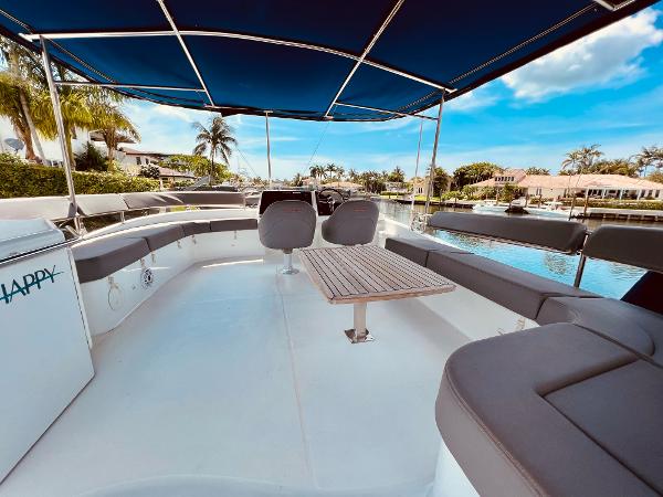 Slide: The Image of 2015 Fountaine Pajot Cumberland 47 LC yacht deck with seating and table, under blue canopy. - 16