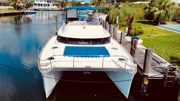 Slide: The Image of 2015 Fountaine Pajot Cumberland 47 LC catamaran docked in a scenic canal. - 5