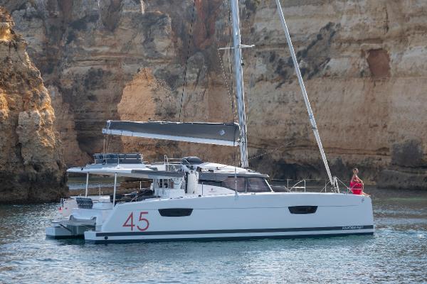 Slide: The Image of 2024 Fountaine Pajot Elba 45 catamaran sailing near rocky cliffs. - 0
