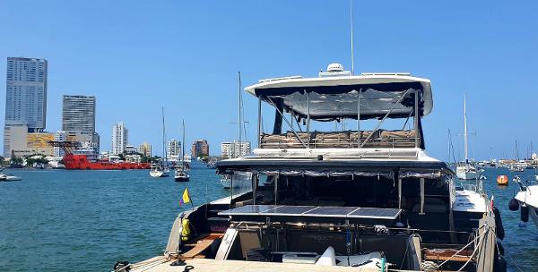 Slide: The Image of 2017 Fountaine Pajot Ipanema 58 Power Catamaran docked in a marina with city skyline. - 25