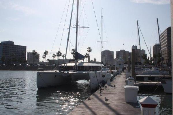 Slide: The Image of 2008 Fountaine Pajot Orana 44 catamaran docked at a marina with city skyline. - 1