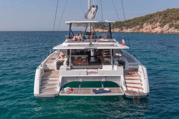 Slide: The Image of 2024 Fountaine Pajot Samana 59 luxury catamaran anchored in clear blue waters. - 1