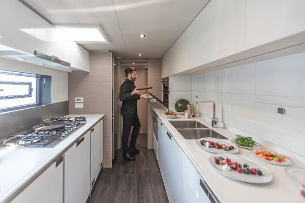 Slide: The Image of Modern kitchen in 2024 Fountaine Pajot Samana 59 yacht with chef preparing food. - 10