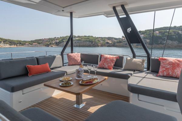 Slide: The Image of 2024 Fountaine Pajot Samana 59 yacht with luxurious outdoor seating and scenic ocean view. - 13