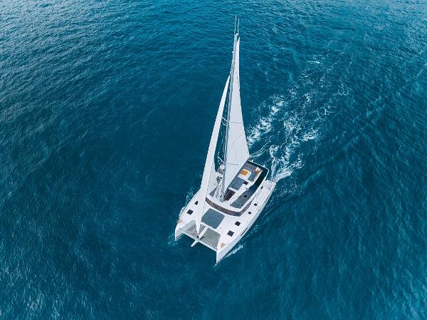 Slide: The Image of Aerial view of 2024 Fountaine Pajot Tanna 47 sailing catamaran on open water. - 2