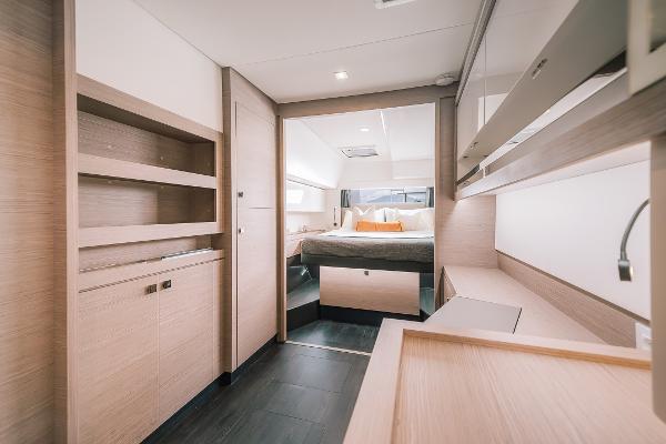Slide: The Image of 2024 Fountaine Pajot Tanna 47 yacht interior, modern bedroom with wooden finishes. - 4