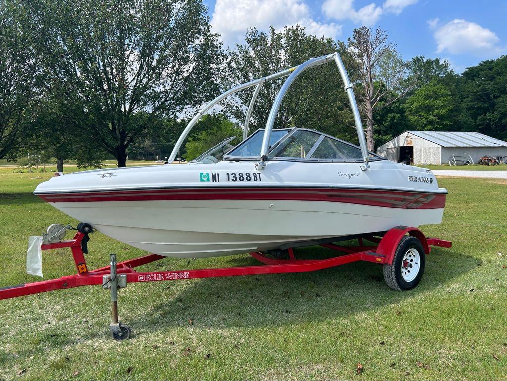 Slide: The Image of 2000 Four Winns Horizon 170 boat on a red trailer, parked on grass. - 1