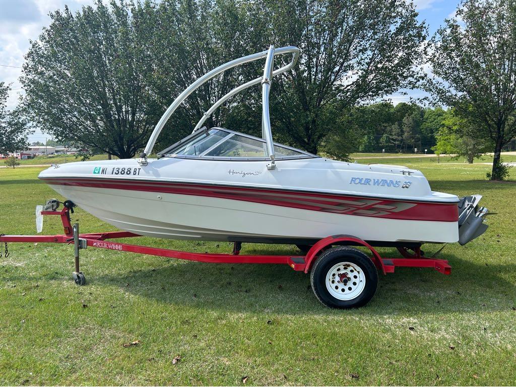 Slide: The Image of 2000 Four Winns Horizon 170 boat on red trailer, parked on grass. - 11