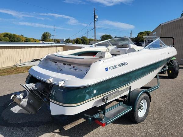 Slide: The Image of 1998 Four Winns 200 Horizon boat on trailer, parked outdoors under clear sky. - 4