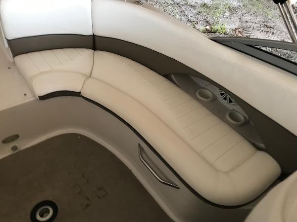 Slide: The Image of 2004 Four Winns 234 Funship boat interior with white cushioned seating and cup holders. - 10