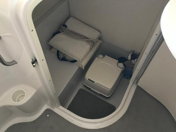 Slide: The Image of 2004 Four Winns 234 Funship boat interior with portable toilet and storage area. - 14