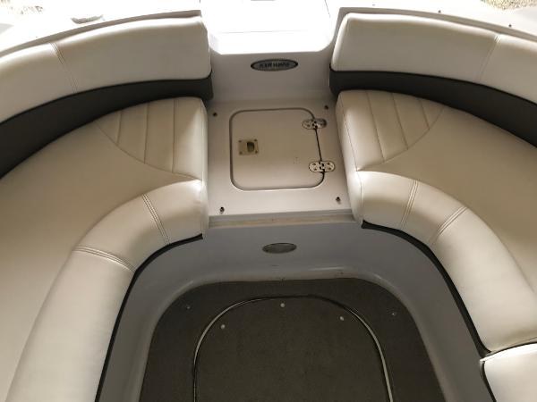 Slide: The Image of 2004 Four Winns 234 Funship boat interior with white cushioned seating and storage compartment. - 18