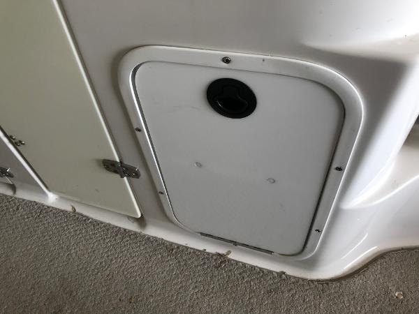 Slide: The Image of 2004 Four Winns 234 Funship boat compartment door with latch on carpeted floor. - 28