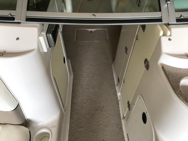 Slide: The Image of 2004 Four Winns 234 Funship boat interior with carpeted floor and storage compartments. - 29