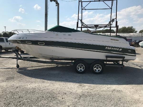 Slide: The Image of 2002 Four Winns 245 Sundowner boat on a trailer in a parking lot. - 1