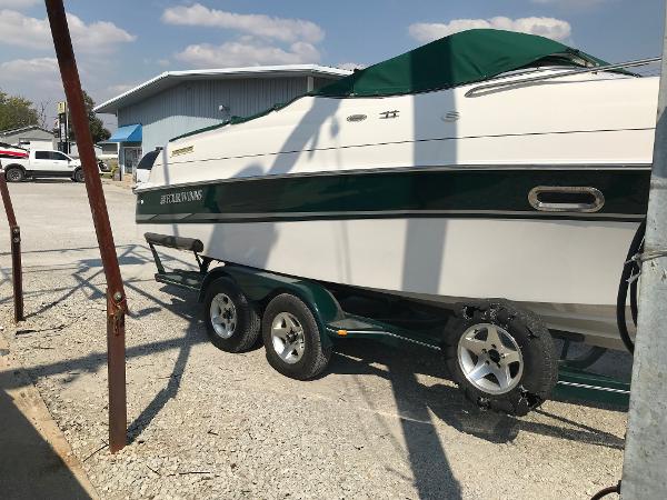 Slide: The Image of 2002 Four Winns 245 Sundowner boat on a trailer in a parking lot. - 3