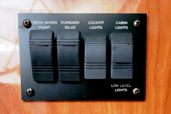 Slide: The Image of Control panel with switches for water pump, bilge, cockpit, and cabin lights on 2004 Four Winns 268 Vista. - 23