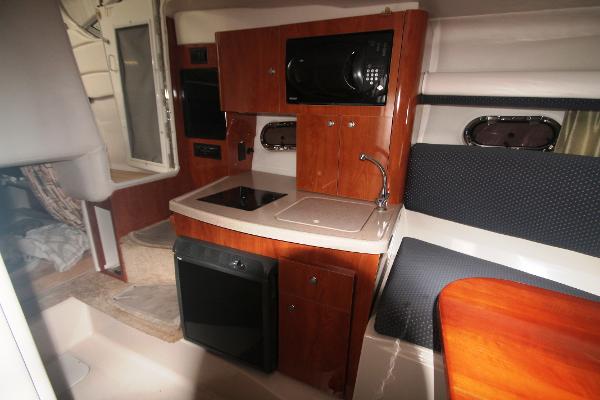 Slide: The Image of 2004 Four Winns 268 Vista cabin interior with kitchenette and seating area. - 28