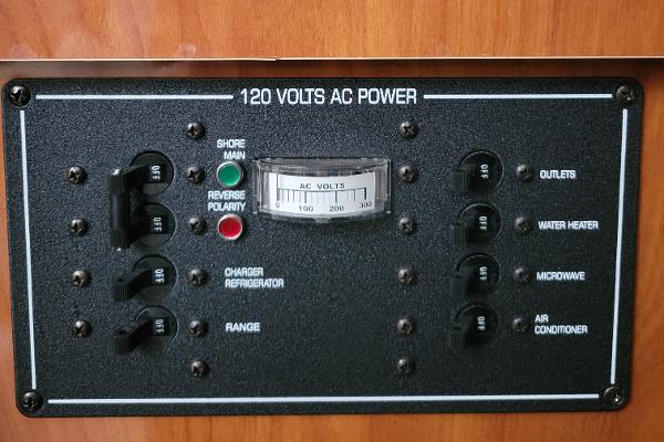 Slide: The Image of Control panel of a 2004 Four Winns 268 Vista boat, showing 120 volts AC power switches. - 33