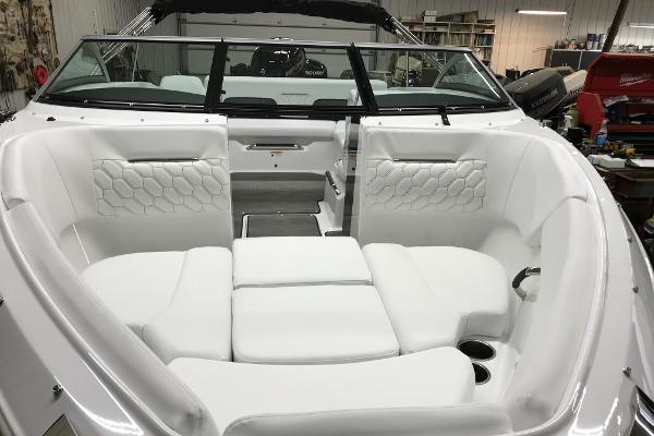 Slide: The Image of 2023 Four Winns H1 OB boat interior with white cushioned seating and modern design. - 13