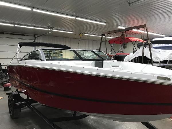 Slide: The Image of 2023 Four Winns H1 OB boat in a showroom, red hull, black canopy. - 3