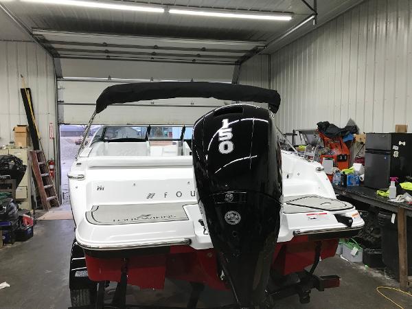 Slide: The Image of 2023 Four Winns H1 OB boat with 150 HP outboard motor in a garage. - 7