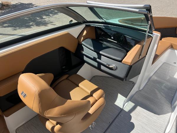 Slide: The Image of 2023 Four Winns H4 boat interior with tan and black seating, modern dashboard, and sleek design. - 14