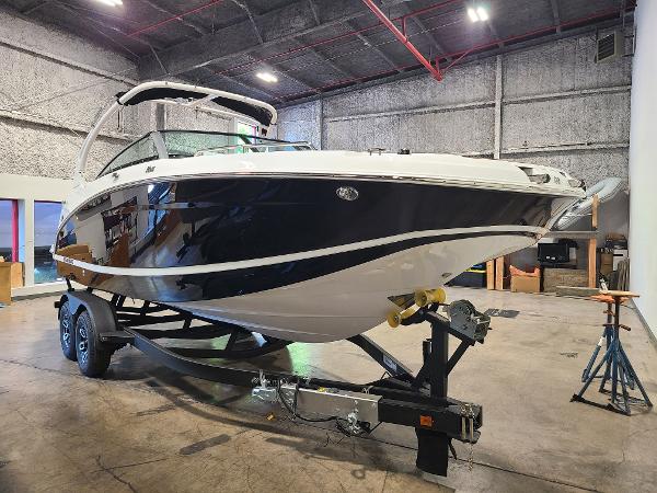 Slide: The Image of 2024 Four Winns HD5 Surf boat on trailer in indoor storage facility. - 1