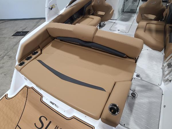 Slide: The Image of 2024 Four Winns HD5 Surf boat interior with tan seating and cup holders. - 10
