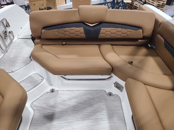 Slide: The Image of 2024 Four Winns HD5 Surf boat with tan and black cushioned seating. - 11