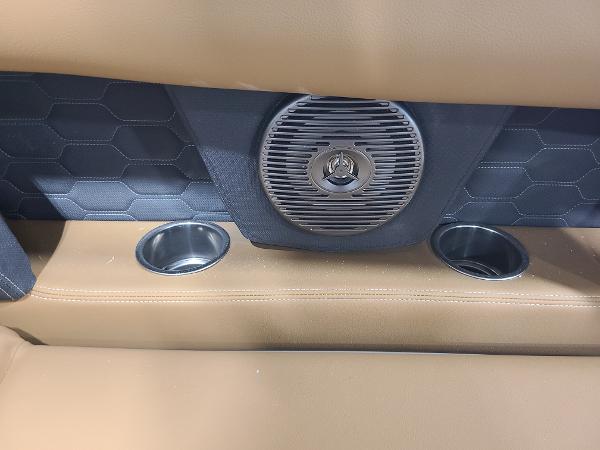 Slide: The Image of 2024 Four Winns HD5 Surf boat interior with speaker and cup holders. - 12