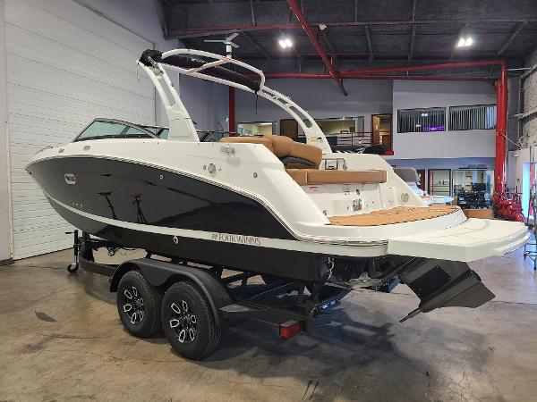 Slide: The Image of 2024 Four Winns HD5 Surf boat on trailer in indoor showroom. - 2