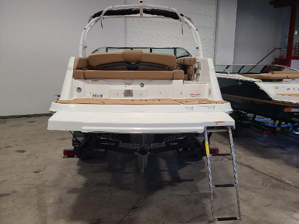 Slide: The Image of 2024 Four Winns HD5 Surf boat with swim platform and ladder in showroom. - 4