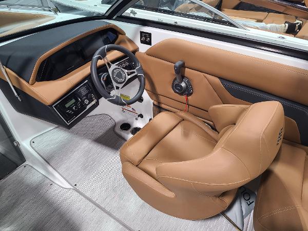Slide: The Image of 2024 Four Winns HD5 Surf boat cockpit with tan leather seats and modern controls. - 6