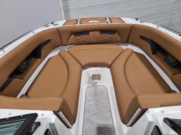 Slide: The Image of 2024 Four Winns HD5 Surf boat with tan leather seating in the bow area. - 9