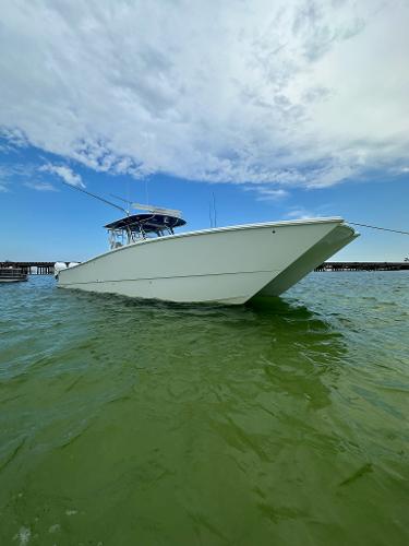 Slide: The Image of 2021 Freeman 42LR boat on calm green water under a partly cloudy sky. - 1