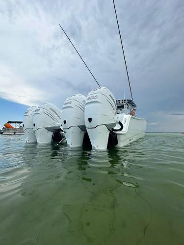 Slide: The Image of Freeman 42LR 2021 boat with triple outboard engines in calm water. - 2