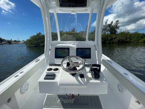 Slide: The Image of 2024 Front Runner 26 Center Console boat helm with dual screens on a sunny day. - 12