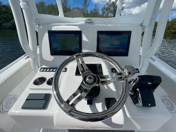 Slide: The Image of 2024 Front Runner 26 Center Console boat helm with dual displays and stainless steel steering wheel. - 13