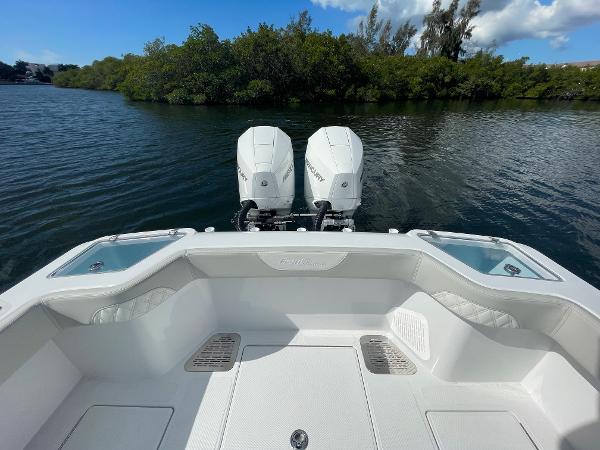 Slide: The Image of 2024 Front Runner 26 Center Console boat with twin Mercury engines on a calm lake. - 8