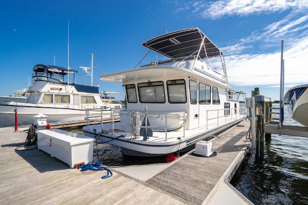 Slide: The Image of 2003 Gibson 47 Classic houseboat docked at marina under clear blue sky. - 0