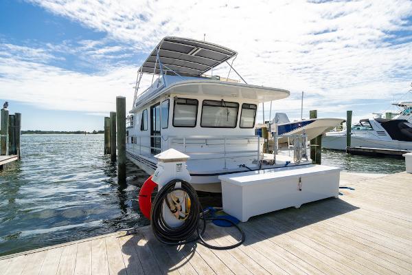 Slide: The Image of 2003 Gibson 47 Classic houseboat docked at marina under sunny skies. - 1