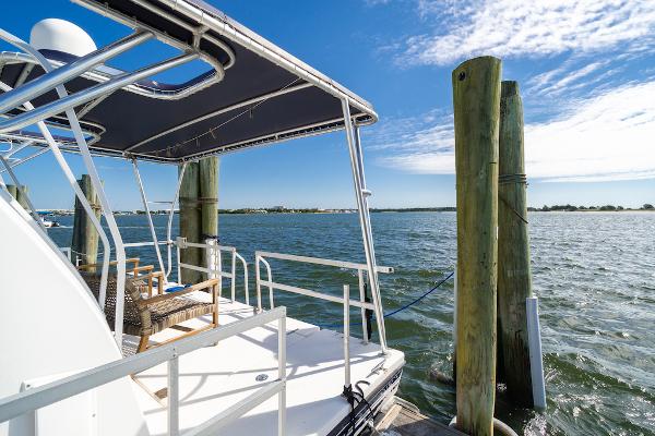 Slide: The Image of 2003 Gibson 47 Classic yacht docked by serene waters under a clear blue sky. - 12