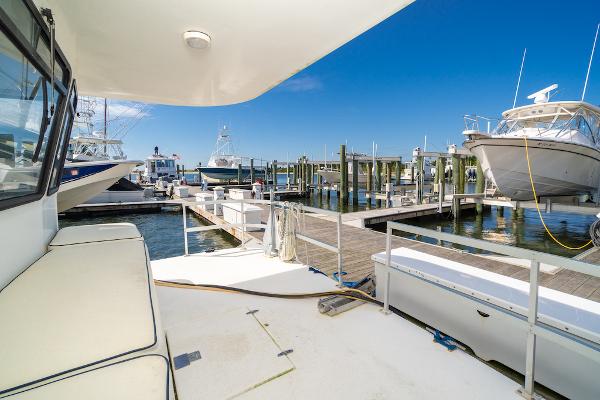 Slide: The Image of Gibson 47 Classic 2003 yacht docked at a marina under clear blue skies. - 14